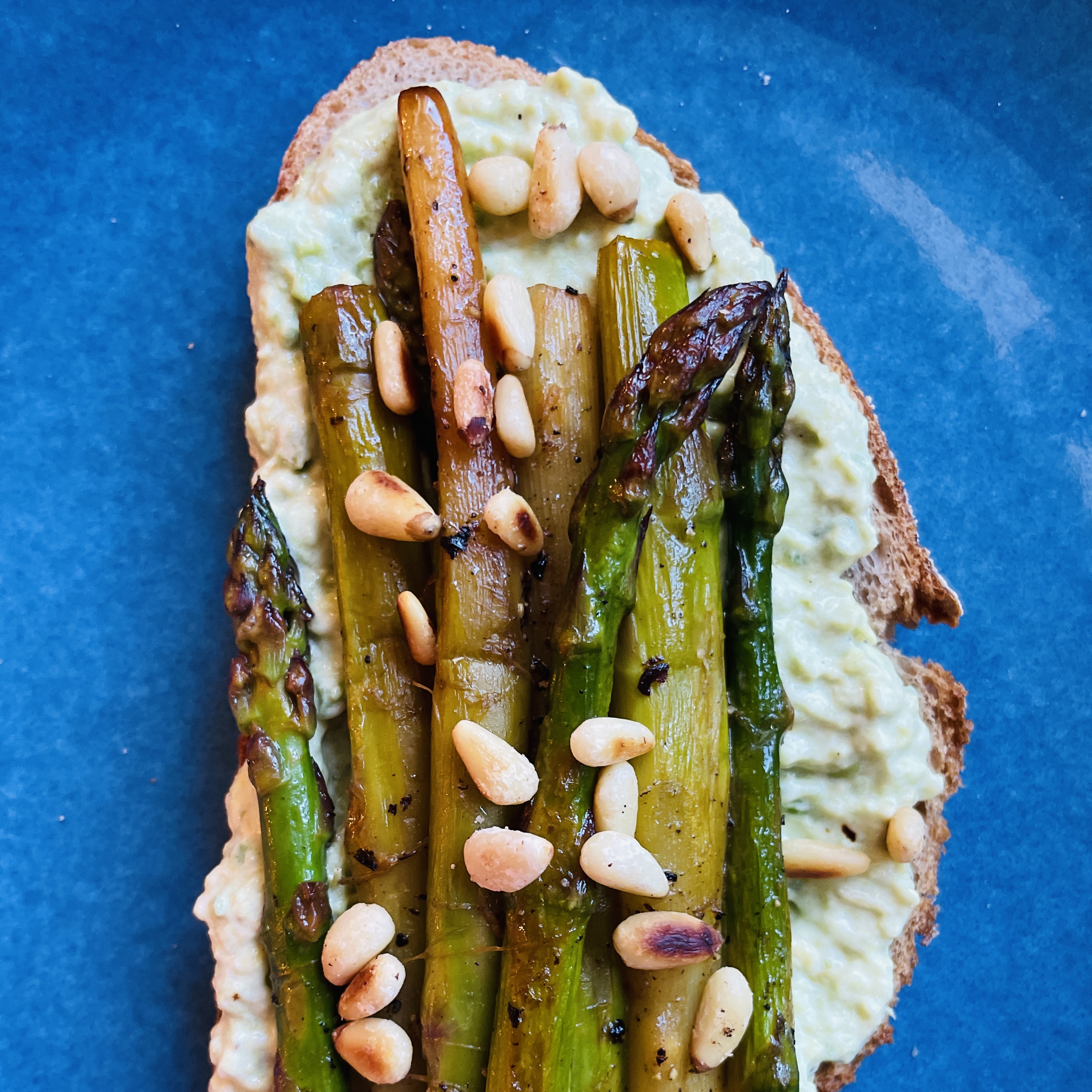 Grüner Spargel mit Burrata und Avocado auf geröstetem Brot